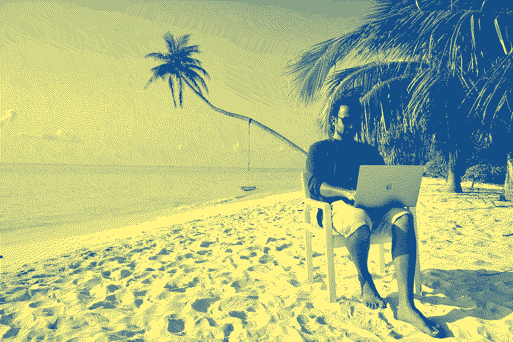 le cliché d'un digital nomad en train de bosser sur la plage